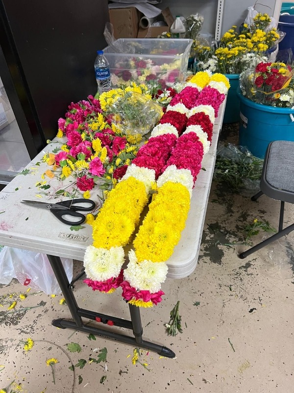 Yellow and rose garland under preparation on table